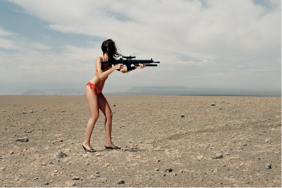 Woman in a red bikini and high heeled shoes holding an assault rifle